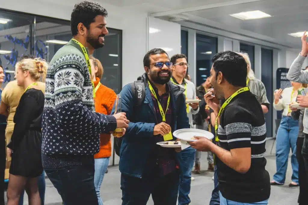 Attendees chatting over drinks and food at the networking reception